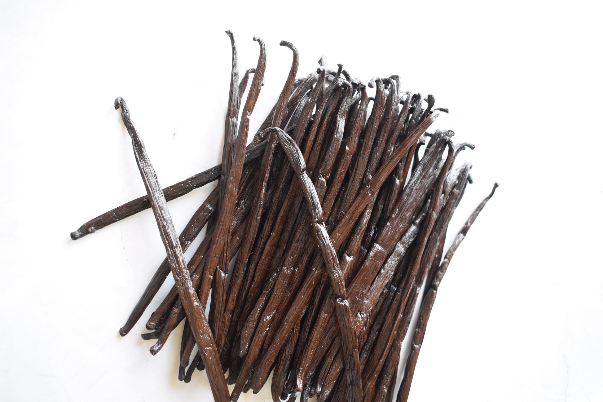 Gousses de vanille bourbon Gourmet croisées sur fond blanc, détail de la qualité Grade A