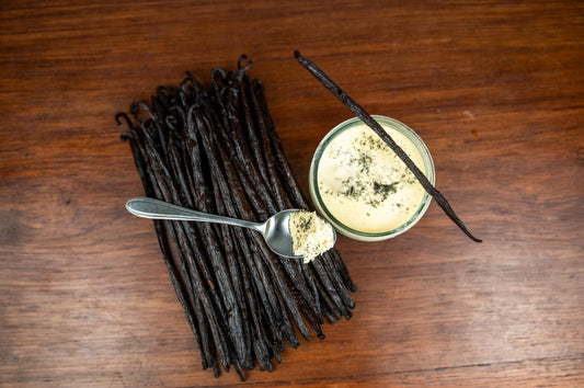 Gousses de vanille bourbon Gourmet disposées sur une table en bois avec une crème dessert à la vanille